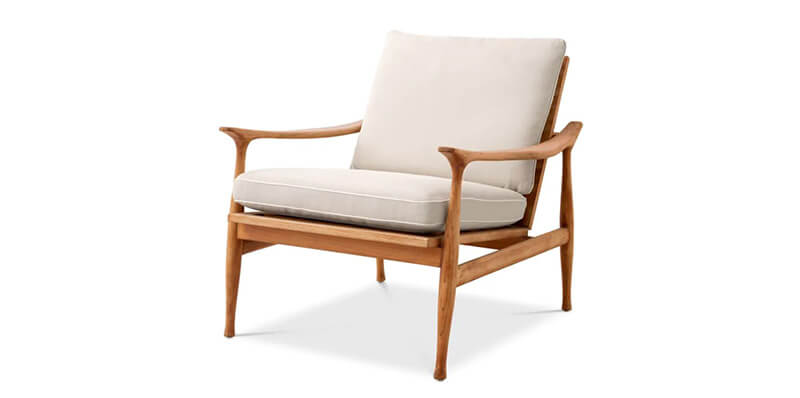 a sustainably sourced teak outdoor chair with cream cushions